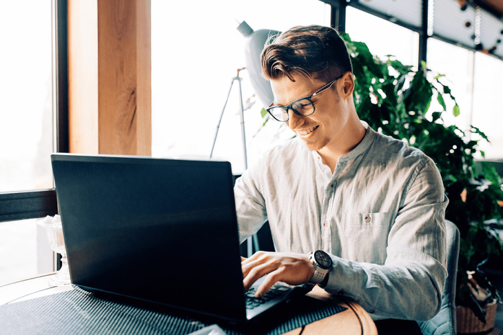 man working on laptop in cafe