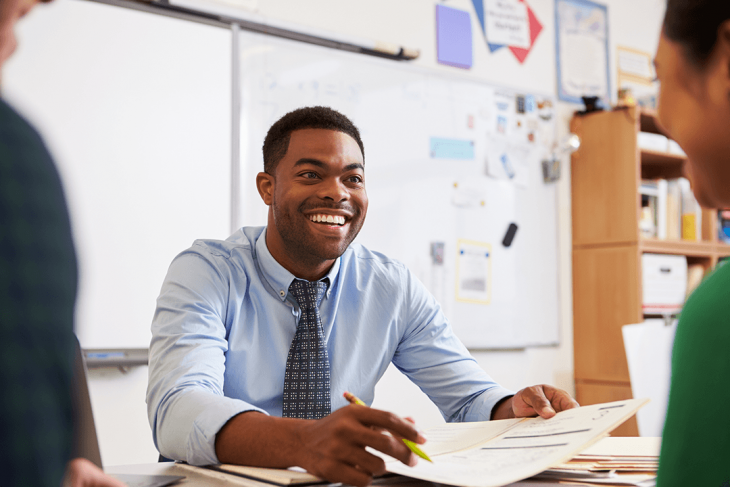 Smiling teacher in classroom with students