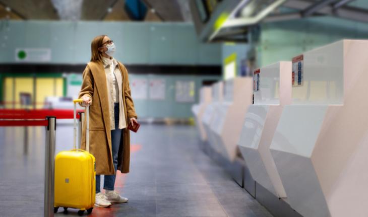 woman wearing a mask at an airport kiosk