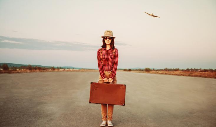 woman carrying a suit case going abroad