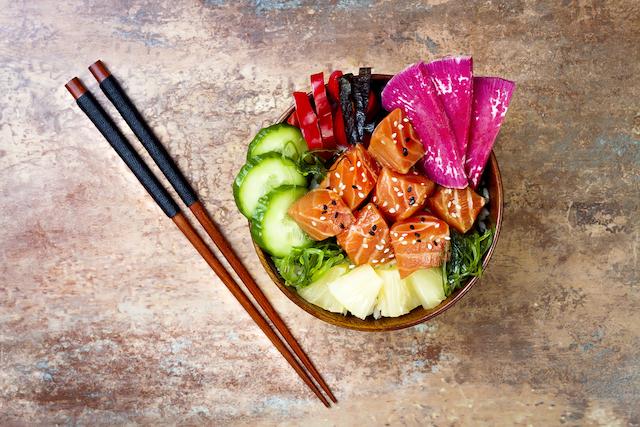 delicious fresh poke bowl with chop sticks laying next to it