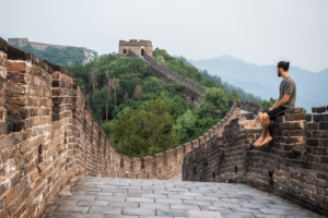 young traveller sitting on Great Wall of China