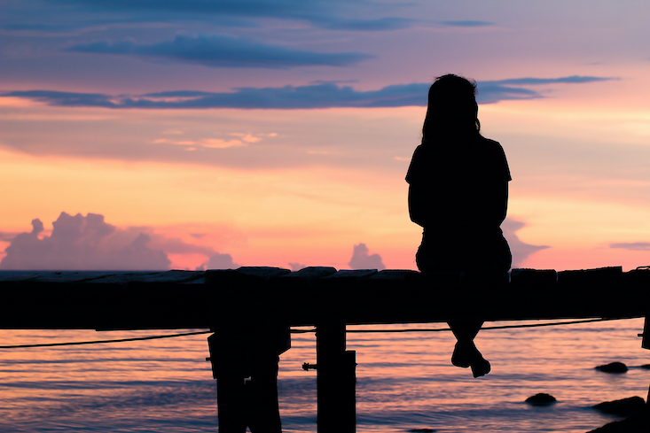 woman sitting at sunset dreaming of travel - how to teach in a different country
