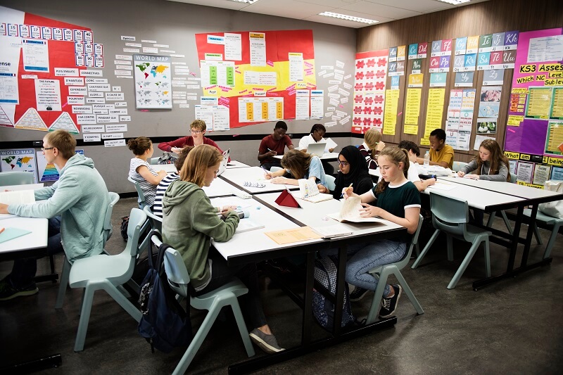 certified teacher in a classroom full of working high school students