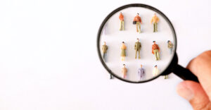 Photo of magnifying glass over people.
