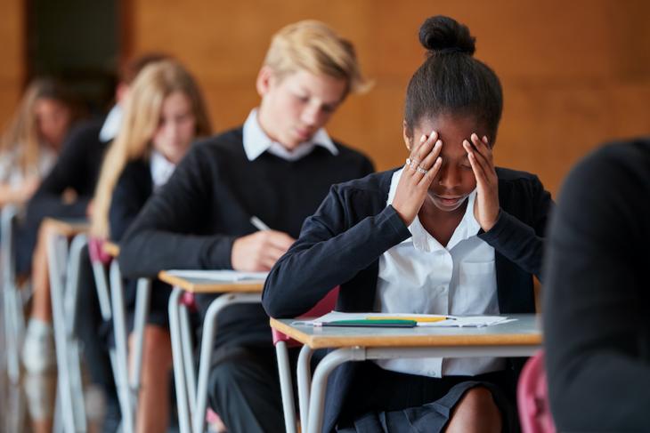 Photo of student struggling on a school test - trauma informed teaching.
