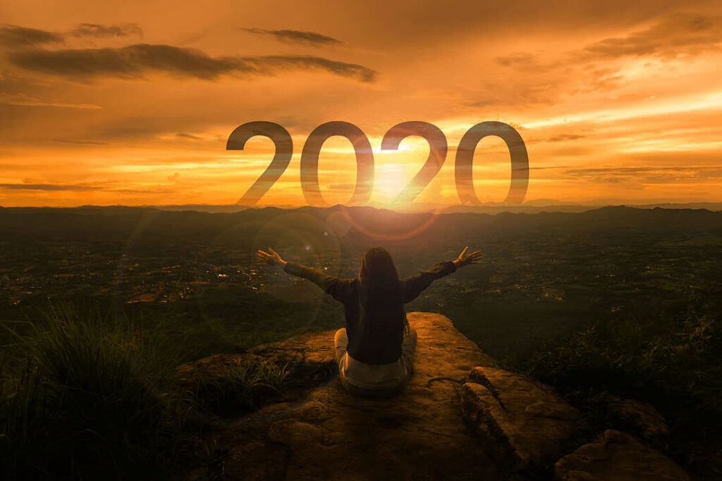 Traveler looking at a sunrise with optimism for 2020
