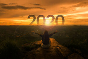 Traveler looking at a sunrise with optimism for 2020