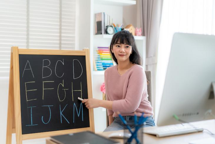 Teaching holding up props for teaching english online.