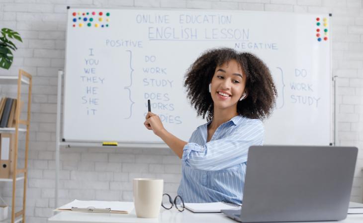 Teacher drawing on props for teaching english online.
