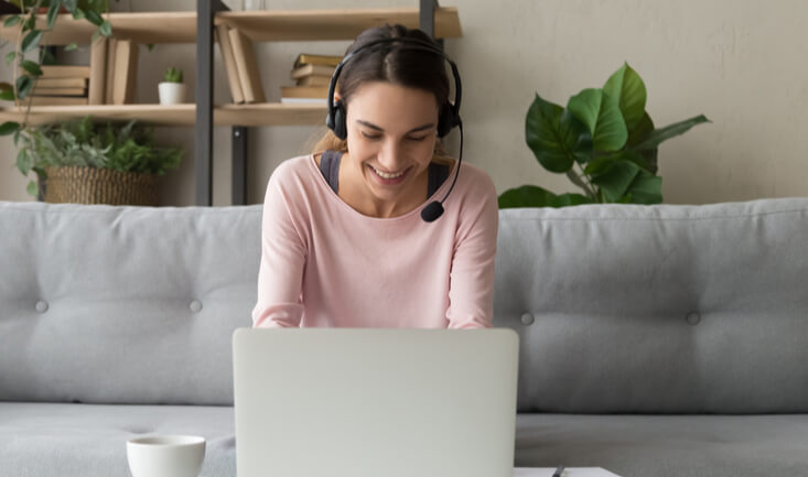 Woman teaching English online from home in front of her laptop.