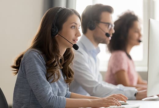 Recruitment Management A woman with a headset on, handing education staffing needs for a school client.