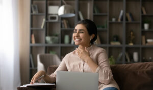 woman sitting on a couch teaching english online for why you should get tefl certified with teach away article