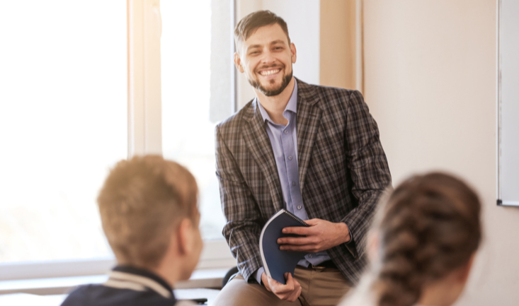 teacher at front of class in front of students
