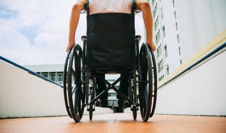 rear view of person in wheelchair on a ramp