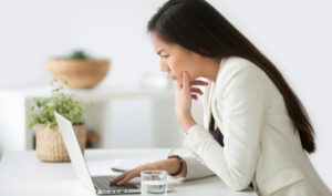puzzled woman looking at a laptop for differences between tefl, tesl, tesol and celta article