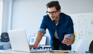man typing on a laptop and downloading online teaching apps