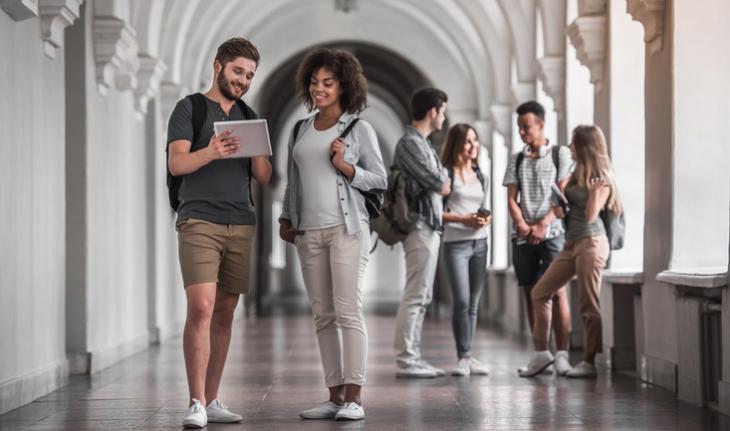 students friends walking down the hallway of a university