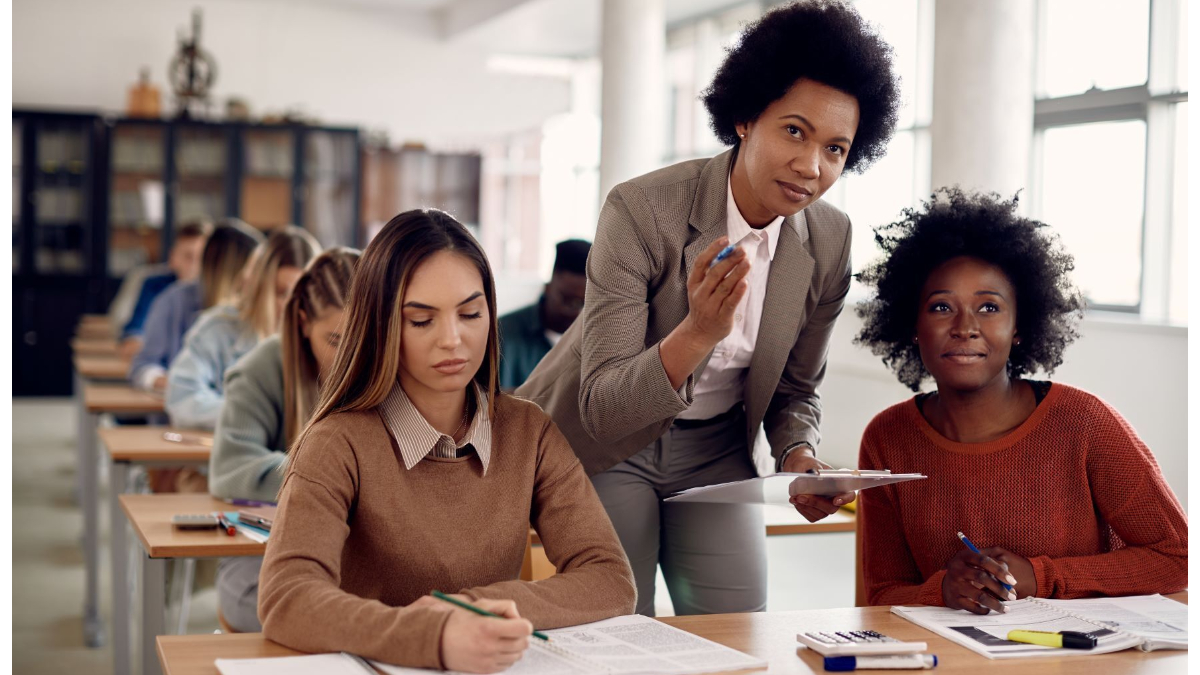 teacher speaking with two students