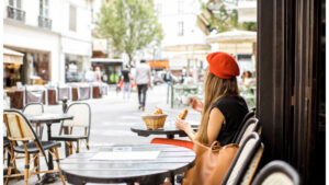 woman in beret sitting at a sidewalk cafe in paris