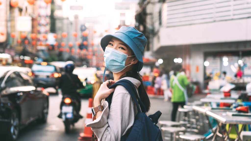woman wearing mask smiling and sightseeing while teaching english abroad in 2022