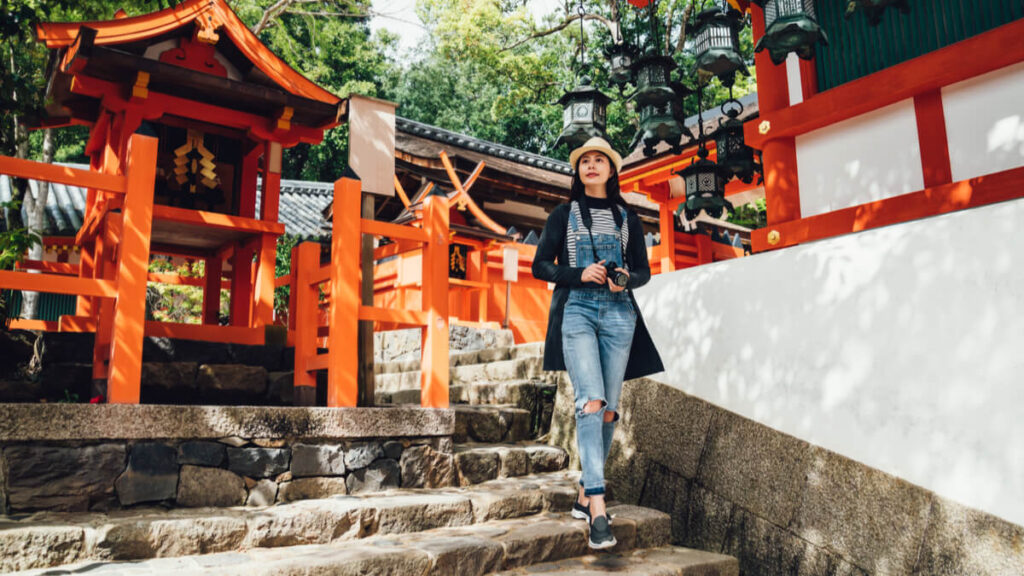 woman in front of temple gates in japan to teach abroad