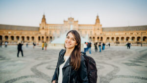 new esl teacher standing in front of plaza de espana in seville, spain teaching english in spain