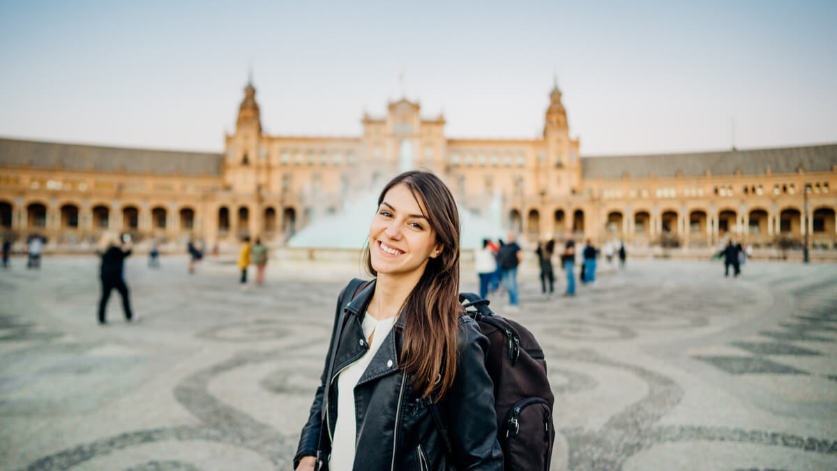 new esl teacher standing in front of plaza de espana in seville, spain teaching english in spain