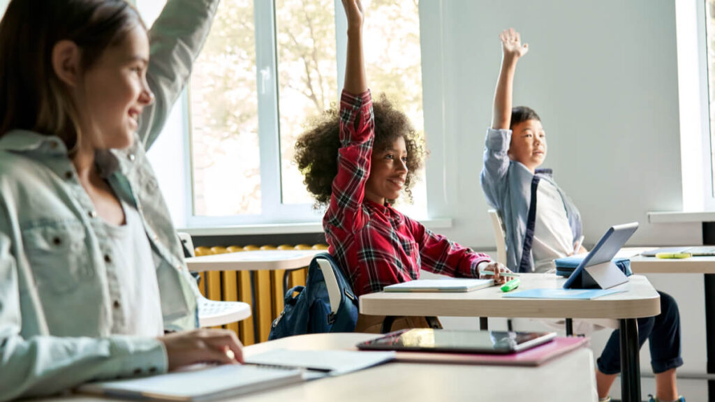 happy middle school students raising their hands are a sign of great teacher stories