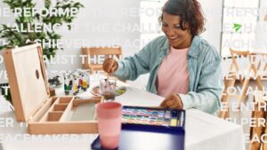 happy new teacher painting at a table after taking her enneagram personality type test for best teaching careers.