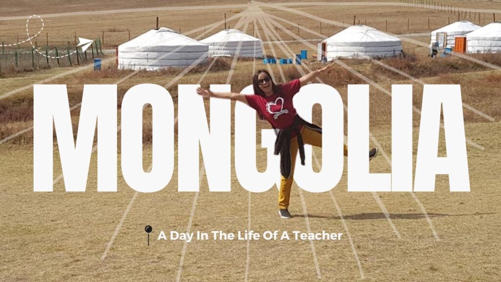 happy teacher jumping in the air in front of a group of gers in mongolia.
