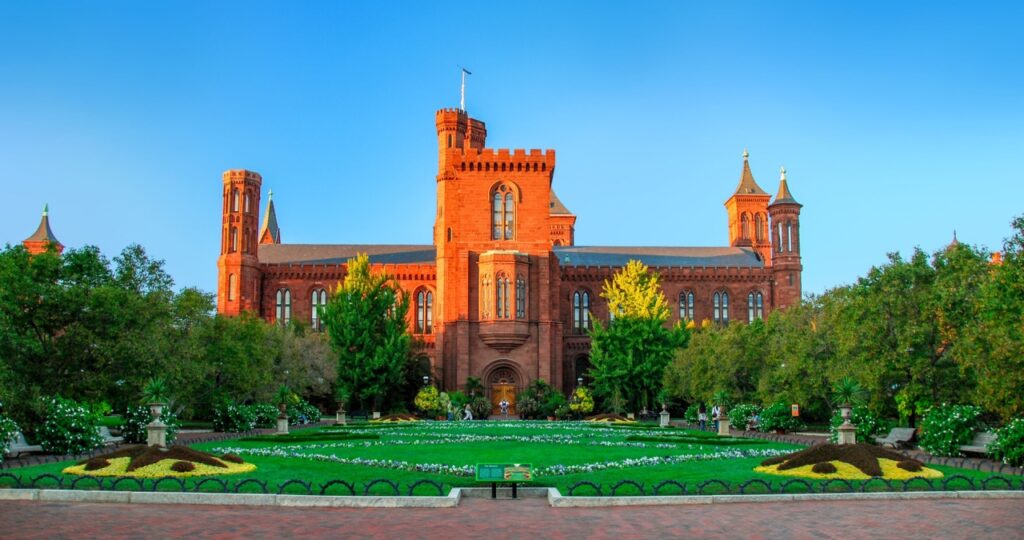 The front Victorian facade of the Smithsonian Castle with beautiful lawn in foreground in Washington, District of Columbia, USA